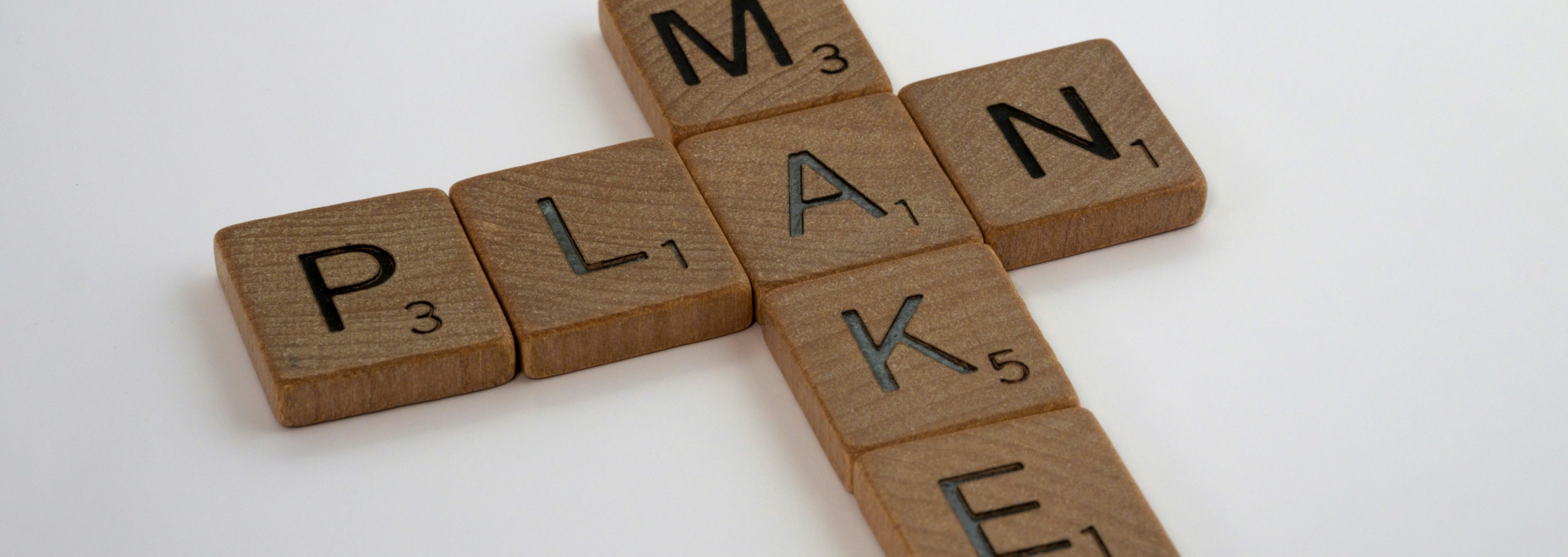 Wooden letter tiles spelling the words plan and make